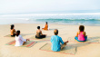 7522212-group-of-people-doing-yoga-on-beach